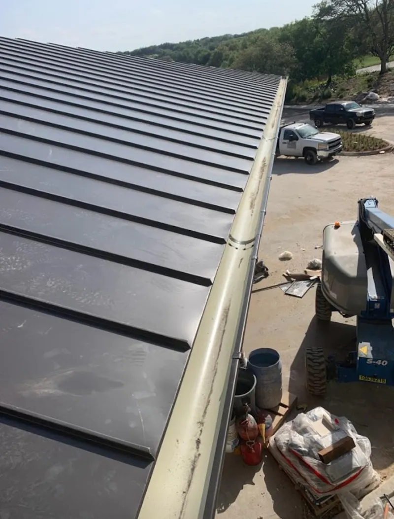 Standing seam panel and gutter detail on a metal roofing jobsite in Fort Lee